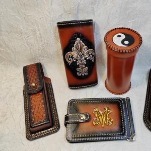 Небольшой заказ. Зажим для денег с монограммой &#34;М&#34; 2, стаканчик из кожи для настольных игр &#34;Инь-янь&#34;, ключница женская &#34;Вензель&#34; 2, ножны под финку НКВД со штампингом 2, ножны под финку НКВД  без штампинга. Изделия из кожи. СКСтиль.
Резьба по коже, карвинг, тиснение по коже, акрил-полиуретан на коже, аэрография.
Изделия выполнены из натуральной кожи растительного дубления, КРС. Изображения выполнены в технике ручного тиснения и окрашивания. Прошиты вручную. Все срезы кожи скруглены, отшлифованы и окрашены. Это позволяет защитить кожу от вымывания дубильных веществ и жиров, увеличивая срок ее службы, и придает изделию более эстетичный и законченный вид. Изделия изготавливаются под заказ. Изображения и конструкция могут быть изменены по вашему желанию. Эскизы и декор делаем по фото или по картинкам из интернета. Можно совместить элементы с разных изображений.