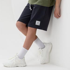 Детские широкие шорты до колена отлично подойдут мальчику для физкультуры и тренировок в зале, а так же для повседневного и домашнего использования. Свободные, пояс на резинке со шнурком и функциональными карманами, в которые помещается даже телефон и ключи. Выполнены из высококачественного хлопкового трикотажного полотна (футера двунитки), которое дышит. Ребенку комфортно в такой одежде, т.к. на 95 % материал состоит из хлопка. Благодаря наличию в составе 5 % лайкры изделие держит форму и меньше мнется. Оверсайз модель хорошо сидит и на худеньких подростках и ребят покрупнее. Универсальный низ летом можно сочетать с футболками и майками. Они подходят для футбола, баскетбола и других активных игр на улице.