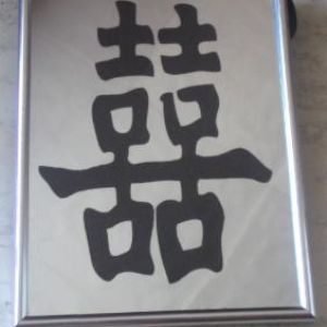 плакетка серебряного цвета с иероглифом. 