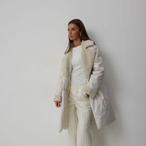 Цвета: молочный, черный
Пальто стёганое, прямого силуэта:  
– длина миди  
– воротник пиджачного типа (из букле)  
– двухбортное  
– по переду — прорезные карманы с листочкой  
– рукав спущенный, одношовный  
– манжеты из букле  
– по переду — двубортная застёжка  
– застёжка на потайные пробивные кнопки  
– на подкладке  
– утеплитель Isosoft 250 г