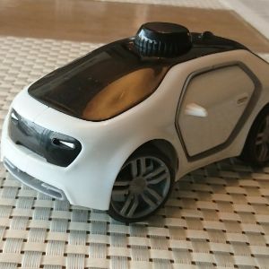Детская игрушка, машинка T-car (Титойз)с управлением поворотом колес. Развивающая игрушка для детей от 3-х лет. Белого цвета. Закрытые двери, обычные колеса. Вид спереди.