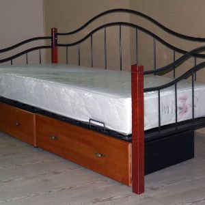 Кровать "Гарда 8" ― одноместная кровать-диван, выполненная из комбинированных материалов ― металла и массива березы. Производство ― Россия. Идеальное решение для гостиной или загородного дома. Спинка-изголовье выполнена из гнутого металла, образует красивый ажурный элемент, легкий и не навязчивый. Удобное боковое изголовье защищает стену от истирания. А также служит дополнительной опорой, на которую для большего комфорта вы можете облокотиться во время чтения или просмотра телевизора. Особенности конструкции позволяют сочетать преимущества нескольких предметов мебели. Кровать "Гарда 8"― это одновременно и кровать, и диван. 
Особенность кроватей из фигурного металла ― внешняя легкость и воздушность при имеющейся надежной конструкции и прочности материала. У данной кровати небольшие габаритные размеры, что актуально для комнат с маленькой площадью. 
ЦВЕТ каркаса (металла) ― черный матовый, ЦВЕТ березы ― орех.
Кровать "Гарда 8"- отечественный аналог очень популярной малазийской кровати. Проект разработан в рамках политики импортозамещения. ЦВЕТ каркаса (металла) ― черный матовый, ЦВЕТ березы ― орех. Мебель "Гарда " российского производства незначительно отличается по внешнему виду и цвету деревянных элементов. Вместо массива гевеи используется массив берёзы. Главным преимуществом данного нововведения является значительно более надёжная конструкция мебели, отсутствие типичных для малайзийской мебели проблем с прочностью конструкции, скрипом ламелей, повреждениями в ходе транспортировки и многократных погрузочно/разгрузочных работ.

Отличительные особенности кроватей Кровать Гарда":

- заменены врезные ламели на накладные (для исключения стука и скрипов). Данное отличие не только усиливает саму царгу за счёт меньшего количества вырезанного металла, но также избавляет кровать от одного из основных недостатков — скрипа ламелей. Плюс небольшие пластиковые заглушки в местах крепления дополнительных ножек, что смотрится очень эстетично.

- машинная обработка деревянных элементов. Все деревянные элементы изготавливает станок с ЧПУ, что исключает отличия элементов, а также позволяет рисунку элемента выглядеть более чётким и глубоким.

- замена «сквозного» перехода витков в изголовье на «перекрестный», что обеспечивает отсутствие сварочных швов. Трубы проходят одна за другой, составляя плавный и изящный рисунок.

- замена крепления футоркой на крепление саморезом по дереву.

- незначительное изменение ножек. Ножки (и все деревянные элементы) отличаются от оригинала по цвету и фактуре дерева. Поэтому цвет российского аналога назван «Орех». Он чуть интенсивнее.

- съемные матрасодержатели. На российском аналоге матрасодержатели снимаются, а в оригинале — приварены намертво. Такой вариант даёт большую свободу, можно не устанавливать вовсе.

- толщина металла (для увеличения прочности и надежности). Профиль квадратной трубы у российского аналога такой же, как у малайзийского оригинала — 3*3 см, но толщина самой стенки не 1 мм, а 1,5 миллиметра! Это значительное отличие, которое при учёте дополнительных ножек снимает ограничения по весу в 90 кг (Малайзия) и устанавливает эту планку на уровень до 120 кг на спальное место (Россия).

По желанию можно комплектовать кровать выкатными ящиками на колесных опорах. Размер ящика 90х75х28 (шхдхв). Цена за 1 ящик ― 3100 руб.